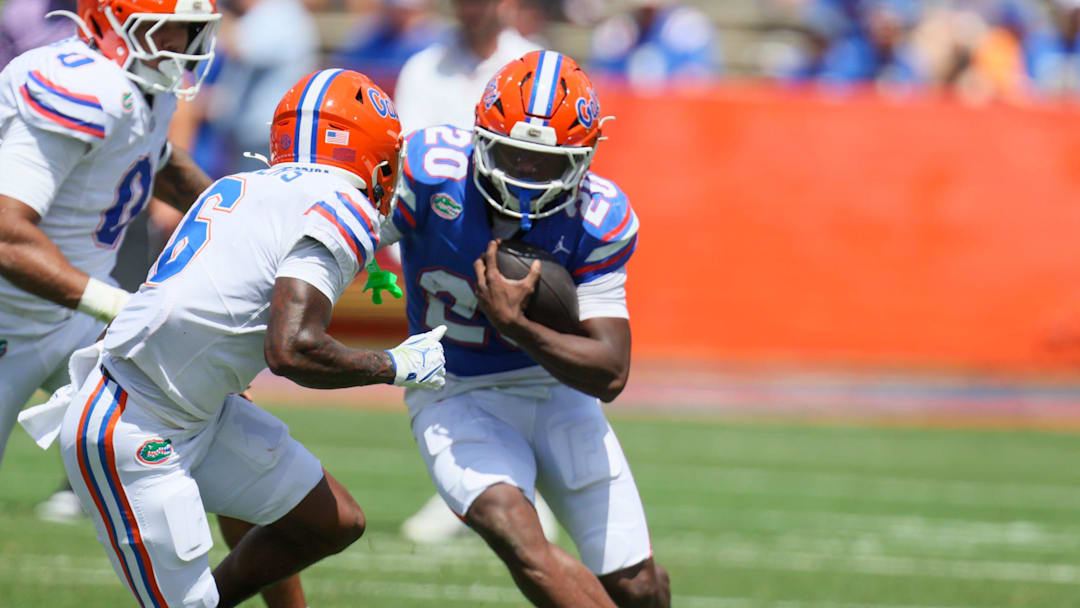 Florida running back Duke Clark (20) gets stopped by Florida cornerback J'Vari Flowers (6) during the second half of the Orange and Blue game at Steve Spurrier Field at Ben Hill Griffin Stadium in Gainesville, FL on Saturday, April 11, 2026. [Alan Youngblood/Gainesville Sun]