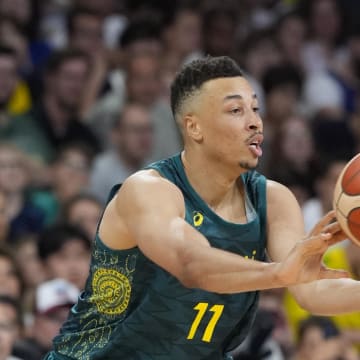 Jul 30, 2024; Villeneuve-d'Ascq, France; Australia point guard Dante Exum (11) passes the ball away from Canada centre Khem Birch (92) in a men's group stage basketball match during the Paris 2024 Olympic Summer Games at Stade Pierre-Mauroy. Mandatory Credit: John David Mercer-USA TODAY Sports