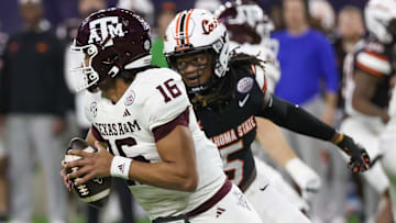 Dec 27, 2023; Houston, TX, USA; Texas A&M Aggies quarterback Jaylen Henderson (16) scrambles from Oklahoma State Cowboys safety Kendal Daniels (5) in the first quarter at NRG Stadium. Henderson was injured on the play and taken out of the game. Mandatory Credit: Thomas Shea-Imagn Images