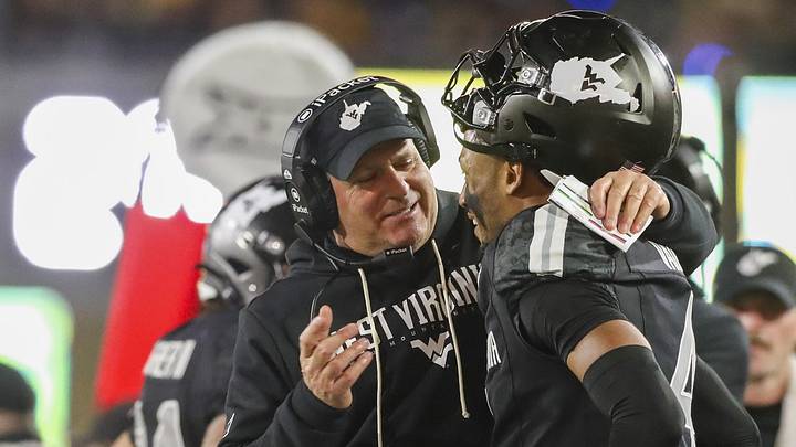 Oct 25, 2025; Morgantown, West Virginia, USA; West Virginia Mountaineers head coach Rich Rodriguez talks with wide receiver Cam Vaughn (4) during the fourth quarter against the Texas Christian University Horned Frogs at Milan Puskar Stadium. Mandatory Credit: Ben Queen-Imagn Images