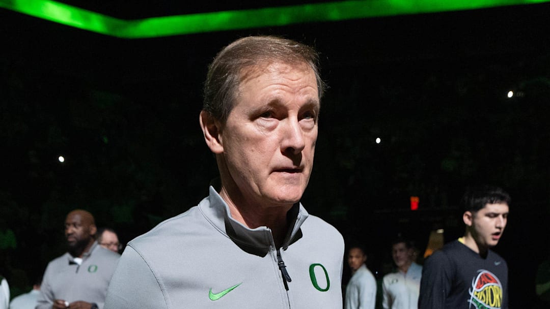 An injured Nate Bittle, left, and Coach Dana Altman take the court for a team meeting before the game against Iowa at Matthew Knight Arena in Eugene Feb. 1, 2026.