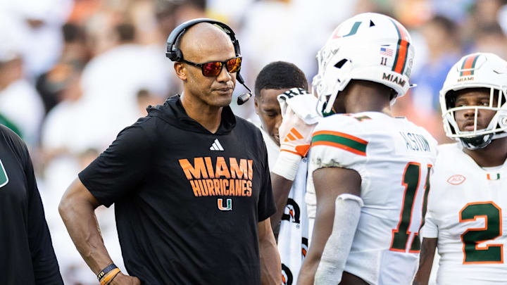 Aug 31, 2024; Gainesville, Florida, USA; Miami Hurricanes defensive line coach Jason Taylor talks with Miami Hurricanes defensive lineman Elijah Alston (11) during a timeout against the Florida Gators during the second half at Ben Hill Griffin Stadium. Mandatory Credit: Matt Pendleton-Imagn Images