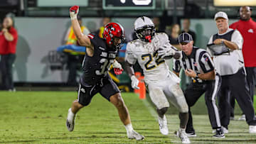 Aug 28, 2025; Orlando, Florida, USA; UCF Knights running back Myles Montgomery (22) is forced out of bounds by Jacksonville State Gamecocks linebacker Aidan Thompson (35) during the second half at Acrisure Bounce House. Mandatory Credit: Mike Watters-Imagn Images