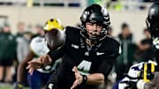 Oct 21, 2023; East Lansing, Michigan, USA;  Michigan State Spartans quarterback Sam Leavitt (4) tosses the ball to Michigan State Spartans running back Nathan Carter (5) in the fourth quarter against the Michigan Wolverines at Spartan Stadium.