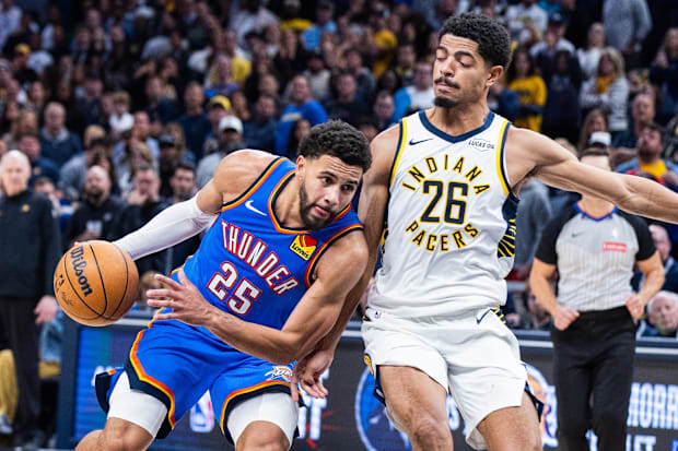 Thunder guard Ajay Mitchell dribbles the ball while Pacers guard Ben Sheppard defends.