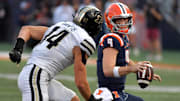 Oct 12, 2024; Champaign, Illinois, USA;  Illinois Fighting Illini quarterback Luke Altmyer (9) eludes Purdue Boilermakers linebacker Yanni Karlaftis (14) in the second half at Memorial Stadium. Mandatory Credit: Ron Johnson-Imagn Images