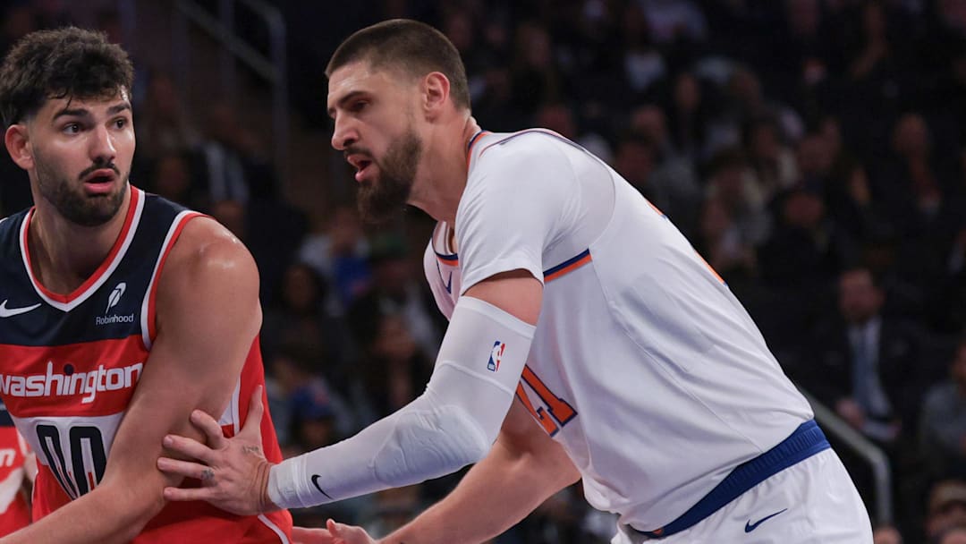 Oct 13, 2025; New York, New York, USA; Washington Wizards forward Tristan Vukcevic (00) looks to pass asNew York Knicks center Alex Len (21) defends during the first half at Madison Square Garden. Mandatory Credit: Vincent Carchietta-Imagn Images