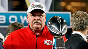 Feb 2, 2020; Miami Gardens, Florida, USA;  Kansas City Chiefs head coach Andy Reid looks at the Vince Lombardi Trophy after beating the San Francisco 49ers in Super Bowl LIV at Hard Rock Stadium. Mandatory Credit: Matthew Emmons-Imagn Images