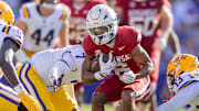 Arkansas Razorbacks wide receiver Raylen Sharpe (6) runs against LSU Tigers defensive back A.J. Haulcy (13) and linebacker Harold Perkins Jr. (7) during the second half at Tiger Stadium.