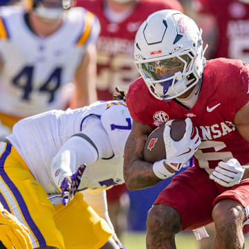 Arkansas Razorbacks wide receiver Raylen Sharpe (6) runs against LSU Tigers defensive back A.J. Haulcy (13) and linebacker Harold Perkins Jr. (7) during the second half at Tiger Stadium.