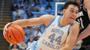 Dec 7, 2025; Chapel Hill, North Carolina, USA;  North Carolina Tar Heels guard Luka Bogavac (44) with the ball as Georgetown Hoyas center Julius Halaifonua (11) defends in the second half at Dean E. Smith Center. Mandatory Credit: Bob Donnan-Imagn Images