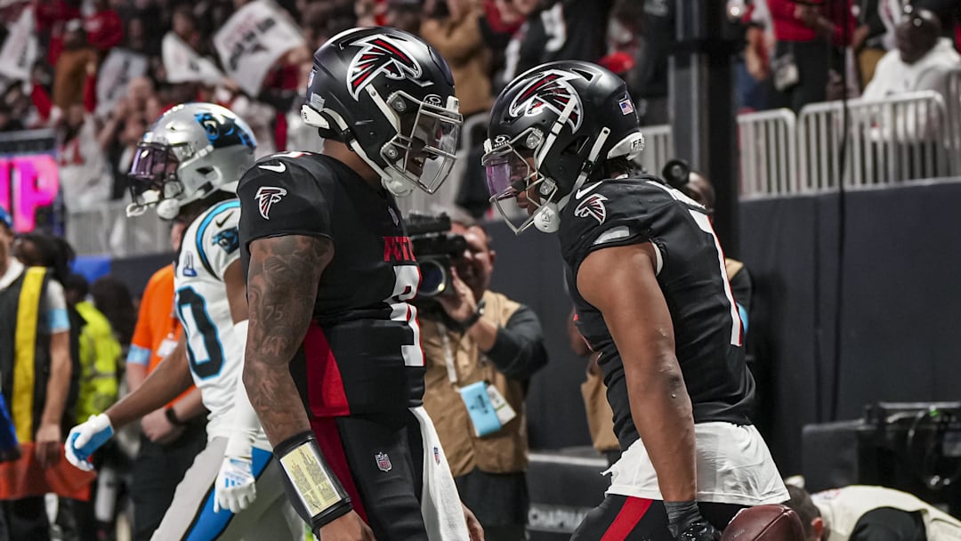 Jan 5, 2025; Atlanta, Georgia, USA; Atlanta Falcons running back Bijan Robinson (7) reacts with quarterback Michael Penix Jr. (9) after running for a touchdown against the Carolina Panthers during the second half at Mercedes-Benz Stadium. Mandatory Credit: Dale Zanine-Imagn Images