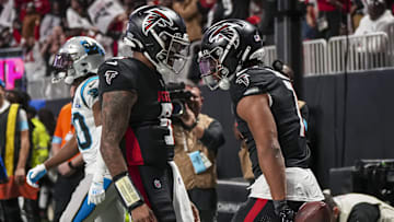 Jan 5, 2025; Atlanta, Georgia, USA; Atlanta Falcons running back Bijan Robinson (7) reacts with quarterback Michael Penix Jr. (9) after running for a touchdown against the Carolina Panthers during the second half at Mercedes-Benz Stadium.