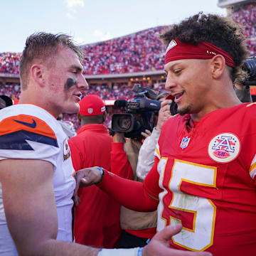Denver Broncos quarterback Bo Nix (10) talks with Kansas City Chiefs quarterback Patrick Mahomes (15) after the game at GEHA Field at Arrowhead Stadium.