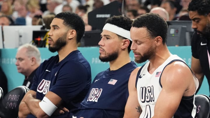 Aug 8, 2024; Paris, France; (L-R) United States forward Jayson Tatum (10), guard Devin Booker (15), guard Stephen Curry (4) look on from the bench during the first half against Serbia in a men's basketball semifinal game during the Paris 2024 Olympic Summer Games at Accor Arena. 