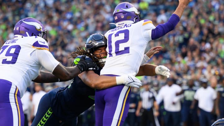 Aug 10, 2023; Seattle, Washington, USA; Seattle Seahawks defensive end Mike Morris (94) hits Minnesota Vikings quarterback Nick Mullens (12) while passing the ball during the first half at Lumen Field. Mandatory Credit: Steven Bisig-USA TODAY Sports