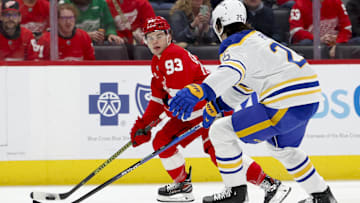Mar 16, 2024; Detroit, Michigan, USA;  Detroit Red Wings right wing Alex DeBrincat (93) skates with the puck defended by Buffalo Sabres defenseman Owen Power (25) in the second period at Little Caesars Arena. Mandatory Credit: Rick Osentoski-Imagn Images
