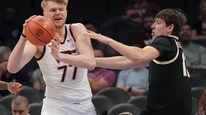 Mar 10, 2026; Charlotte, NC, USA; Virginia Tech Hokies center Antonio Dorn (77) with the ball as Wake Forest Demon Deacons forward Cooper Schwieger (13) defends in the first half at Spectrum Center. Mandatory Credit: Bob Donnan-Imagn Images