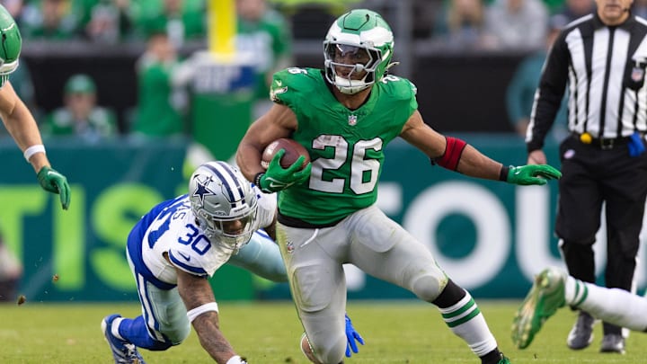 Dec 29, 2024; Philadelphia, Pennsylvania, USA; Philadelphia Eagles running back Saquon Barkley (26) runs with the ball past Dallas Cowboys safety Juanyeh Thomas (30) at Lincoln Financial Field. Mandatory Credit: Bill Streicher-Imagn Images