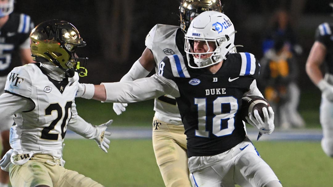 Nov 29, 2025; Durham, North Carolina, USA; Duke Blue Devils wide receiver Cooper Barkate (18) runs the ball against Wake Forest Demon Deacons defensive back Lardarius Webb Jr. (20) during the fourth quarter at Wallace Wade Stadium. Mandatory Credit: Zachary Taft-Imagn Images