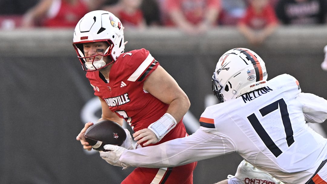 Louisville quarterback Miler Moss has the ball stripped against Virginia