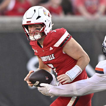 Louisville quarterback Miler Moss has the ball stripped against Virginia