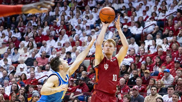 Feb 14, 2025; Bloomington, Indiana, USA; Indiana Hoosiers forward Luke Goode (10) shoots the ball while UCLA Bruins guard Lazar Stefanovic (10) defends in the first half at Simon Skjodt Assembly Hall. Mandatory Credit: Trevor Ruszkowski-Imagn Images