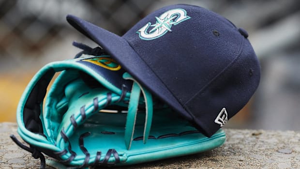 Dark blue Seattle Mariners hat on top of a light blue glove