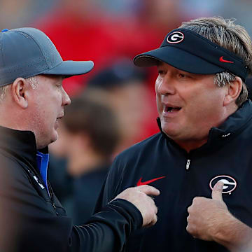 Georgia coach Kirby Smart speaks with Kentucky coach Mark Stoops before the start of a NCAA college football game against Kentucky in Athens, Ga., on Saturday, Oct. 7, 2023.