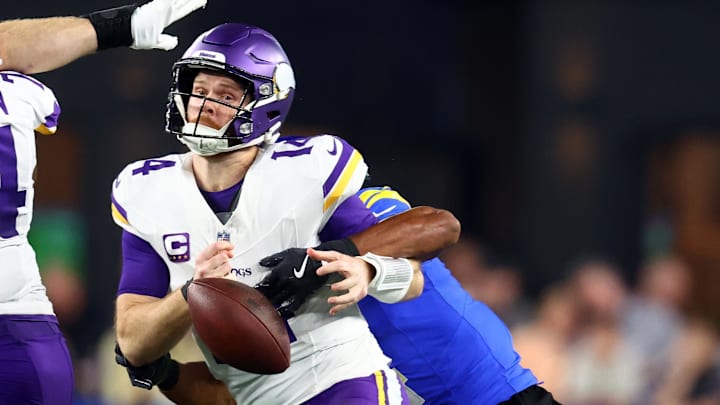 Jan 13, 2025; Glendale, AZ, USA; Minnesota Vikings quarterback Sam Darnold (14) is sacked by Los Angeles Rams cornerback Ahkello Witherspoon (4) during the first half in an NFC wild card game at State Farm Stadium. Mandatory Credit: Mark J. Rebilas-Imagn Images