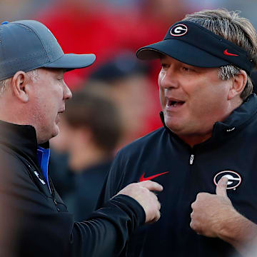 Georgia coach Kirby Smart speaks with Kentucky coach Mark Stoops before the start of a NCAA college football game against Kentucky in Athens, Ga., on Saturday, Oct. 7, 2023.