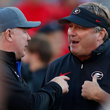 Georgia coach Kirby Smart speaks with Kentucky coach Mark Stoops before the start of a NCAA college football game against Kentucky in Athens, Ga., on Saturday, Oct. 7, 2023.
