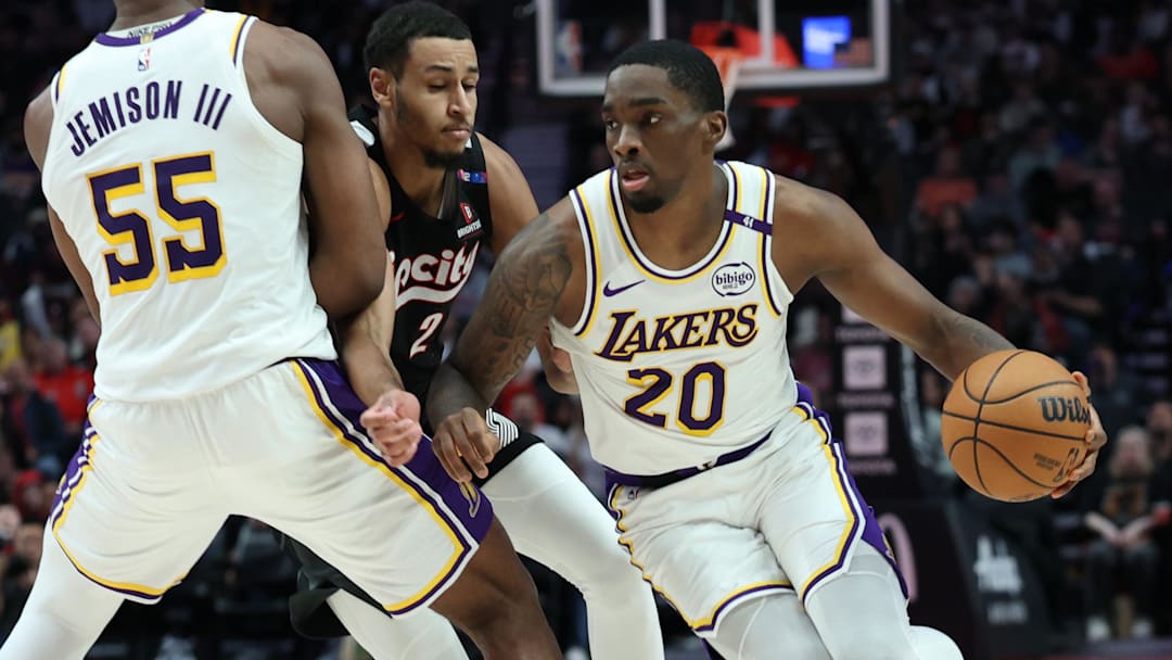 Former Los Angeles Lakers guard Shake Milton (20) dribbles the ball around his teammate, Lakers’ center Trey Jemison III (55), past Portland Trail Blazers forward Kris Murray (24) in the second half at Moda Center.