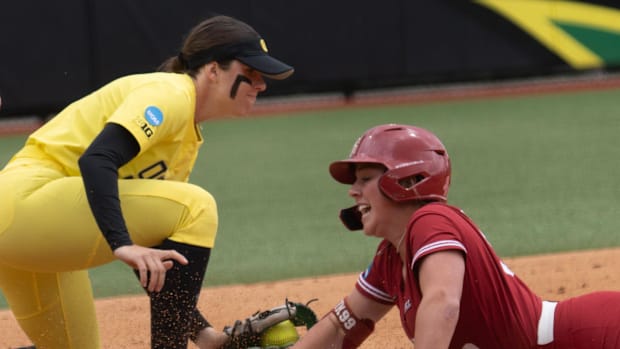 Oregon’s Katie Flannery, left, is late with the tag at third as Stanford’s Taryn Kern slides in safely during the first innin
