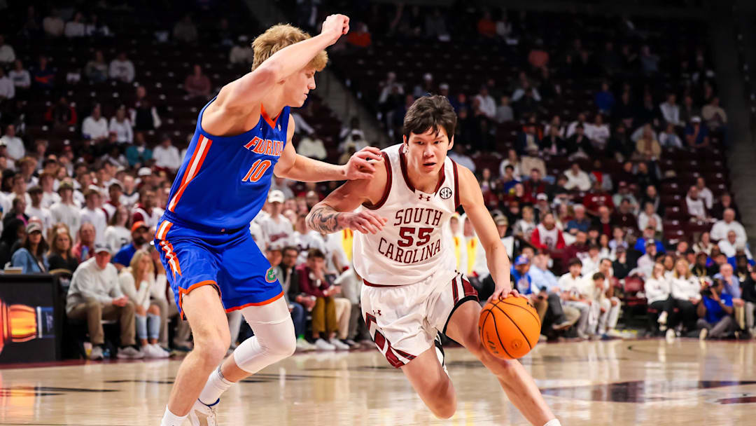 Jan 28, 2026; Columbia, South Carolina, USA; South Carolina Gamecocks guard Mike Sharavjamts (55) attempts to drive around Florida Gators forward Thomas Haugh (10) in the first half at Colonial Life Arena. Mandatory Credit: Jeff Blake-Imagn Images