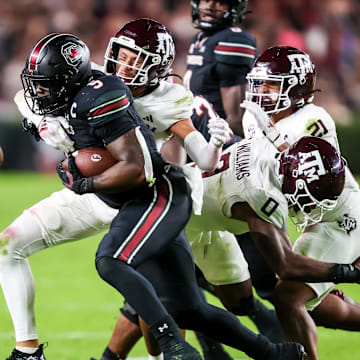 Nov 2, 2024; Columbia, South Carolina, USA; South Carolina Gamecocks running back Raheim Sanders (5) is brought down by Texas A&M Aggies defensive back Marcus Ratcliffe (3) in the second quarter at Williams-Brice Stadium. Mandatory Credit: Jeff Blake-Imagn Images