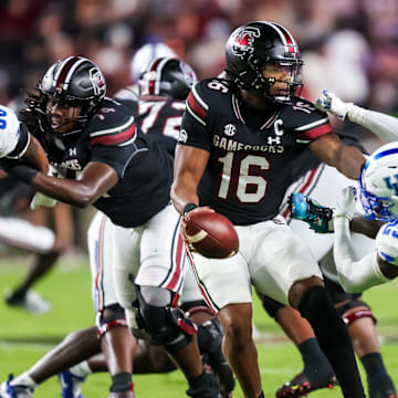 Sep 27, 2025; Columbia, South Carolina, USA; South Carolina Gamecocks quarterback LaNorris Sellers (16) eludes the sack of Kentucky Wildcats defensive back Jordan Lovett (25) in the second quarter at Williams-Brice Stadium. Mandatory Credit: Jeff Blake-Imagn Images