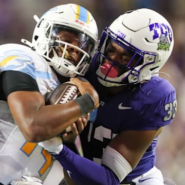 TCU defenders wrap up the Long Island Quarterback for a tackle. 