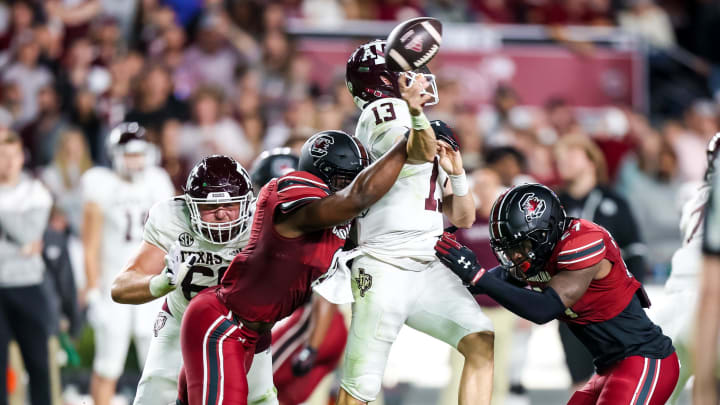 Oct 22, 2022; Columbia, South Carolina, USA; Texas A&M Aggies quarterback Haynes King (13) is hit as he passes by South Carolina Gamecocks linebacker Gilber Edmond (8) and South Carolina Gamecocks defensive back DQ Smith (27) in the second quarter at Williams-Brice Stadium. Mandatory Credit: Jeff Blake-USA TODAY Sports