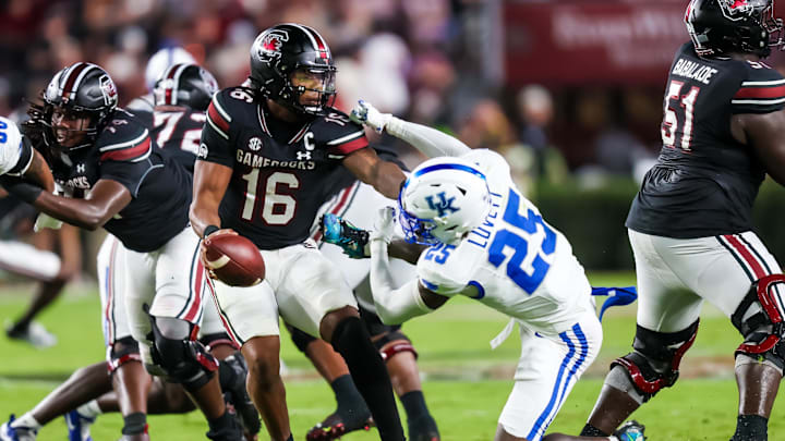 Sep 27, 2025; Columbia, South Carolina, USA; South Carolina Gamecocks quarterback LaNorris Sellers (16) eludes the sack of Kentucky Wildcats defensive back Jordan Lovett (25) in the second quarter at Williams-Brice Stadium. Mandatory Credit: Jeff Blake-Imagn Images
