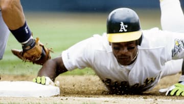 Jul 20, 1991; Oakland, CA, USA; FILE PHOTO; Rickey Henderson of the Oakland Athletics dives back to 1st base ahead of the tag by New York Yankees infielder Don Mattingly (left) at the Oakland Coliseum.  Mandatory Credit: Imagn Images