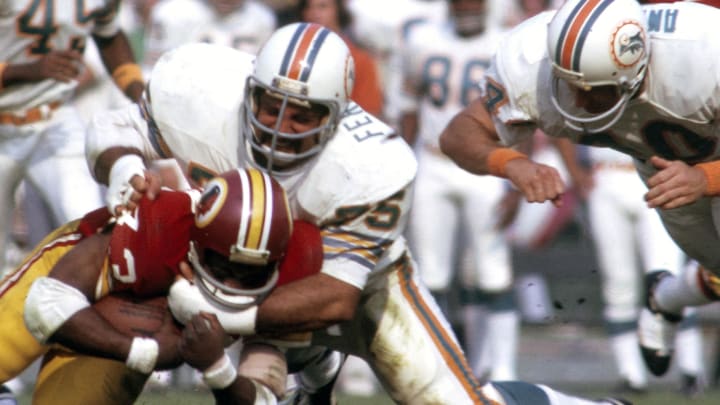 Defensive tackle Manny Fernandez (75) tackles Washington Redskins running back Larry Brown during his dominating performance in the Super Bowl VII victory against Washington at the Los Angeles Coliseum.