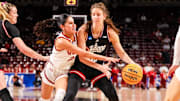Mar 21, 2025; Columbia, South Carolina, USA; Indiana Hoosiers guard Yarden Garzon (12) attempts to drive around Utah Utes guard Ines Vieira (2) in the first half at Colonial Life Arena. Mandatory Credit: Jeff Blake-Imagn Images