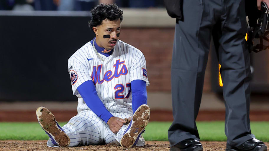Mets first baseman Mark Vientos sits on the ground after being thrown out at home