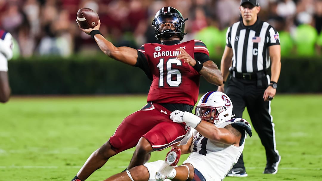 Sep 6, 2025; Columbia, South Carolina, USA; South Carolina Gamecocks quarterback LaNorris Sellers (16) passes as he is brought down by South Carolina State Bulldogs defensive end Mike Lunz (11) in the second quarter at Williams-Brice Stadium. Mandatory Credit: Jeff Blake-Imagn Images