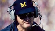 Michigan Wolverines head coach Bo Schembechler on the sideline with quarterback at Michigan Stadium. 