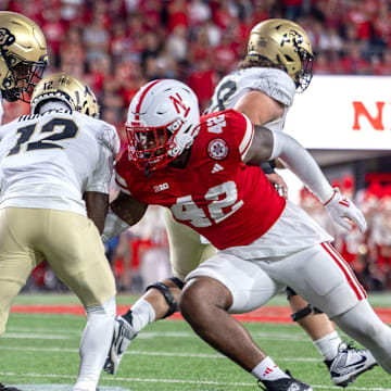 Nebraska defenders Jimari Butler and Mikai Gbayor converge to bring down Colorado's Travis Hunter.