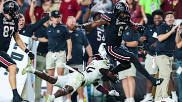 Nov 2, 2024; Columbia, South Carolina, USA; South Carolina Gamecocks tight end Joshua Simon (6) jumps over Texas A&M Aggies defensive back Dalton Brooks (25) while running on a touchdown reception in the second half at Williams-Brice Stadium. Mandatory Credit: Jeff Blake-Imagn Images