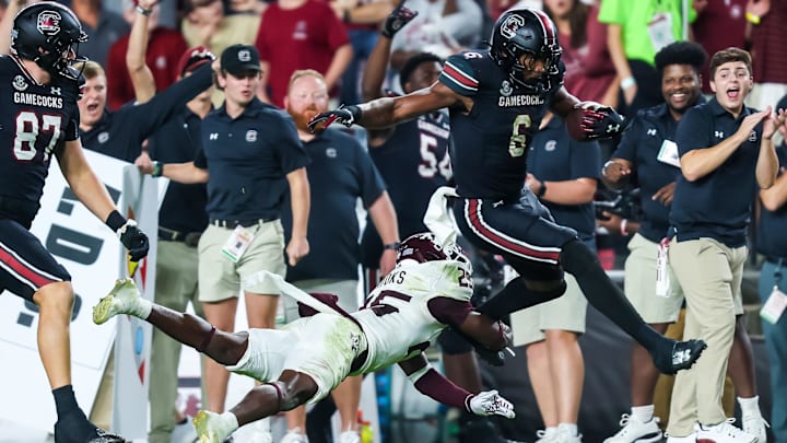 Nov 2, 2024; Columbia, South Carolina, USA; South Carolina Gamecocks tight end Joshua Simon (6) jumps over Texas A&M Aggies defensive back Dalton Brooks (25) while running on a touchdown reception in the second half at Williams-Brice Stadium. Mandatory Credit: Jeff Blake-Imagn Images