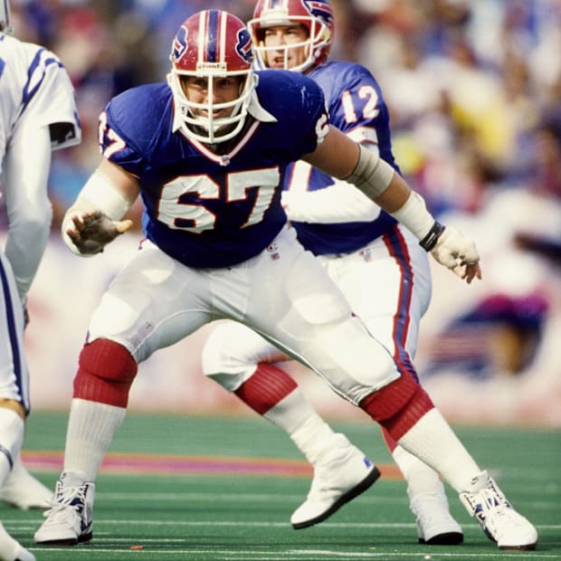 Former Buffalo Bills center Kent Hull blocking while quarterback Jim Kelly prepares to throw.